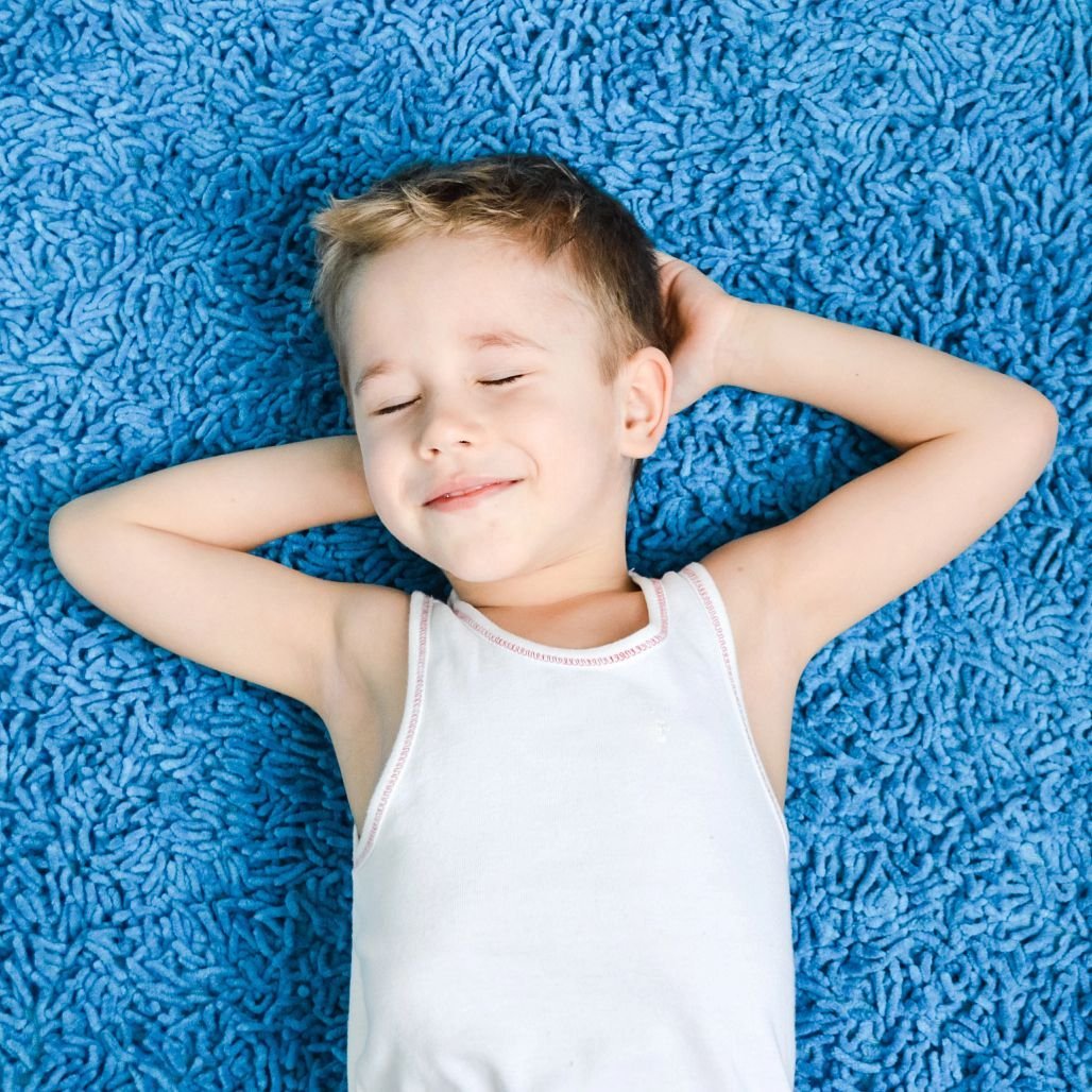 boy relaxing on blue carpet