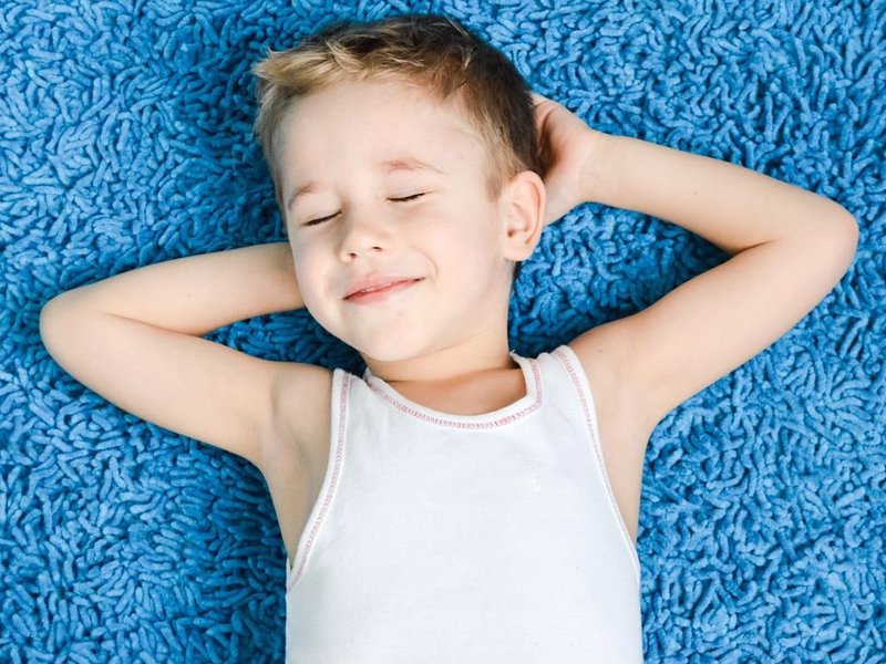 boy relaxing on blue carpet